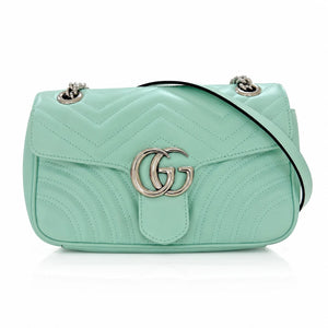 A mint green quilted leather shoulder bag with a silver-tone interlocking G logo on the front, a black strap, and silver-tone chain details, shown on a white background.