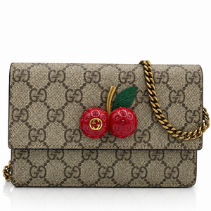 Gucci GG Supreme Monogram Mini Cherry Chain shoulder bag with a gold chain strap and a 3D cherry embellishment on the front, shown on a white background.