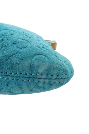 A close-up of a teal blue textured cushion or pillow corner with circular tufted detailing and visible stitching, set against a clean white background.