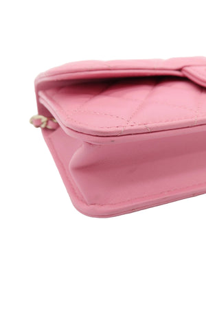 A close-up of a pink quilted leather wallet or clutch with a zip-around closure, shown on a plain white background.