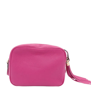 A bright pink pebbled leather crossbody bag with a matching tassel strap, shown against a plain white background.