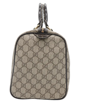 A vintage Gucci handbag in beige and brown GG Supreme canvas with black leather trim and handles, photographed against a white background.