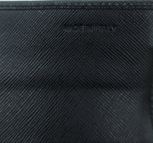 Close-up of a black textured leather pouch or wallet with a debossed logo on a light gray background.