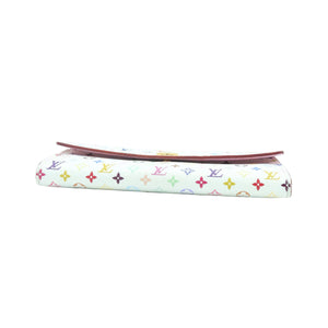 A folded Louis Vuitton monogram canvas clutch or wallet with a white background and multicolor LV logo print, featuring a reddish-brown leather edge visible along the top, set against a plain white background.