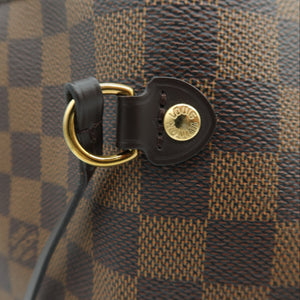 Close-up of a Louis Vuitton handbag in Damier Ebene canvas, showing the brown and tan checkered pattern, black leather trim, and gold-tone hardware.
