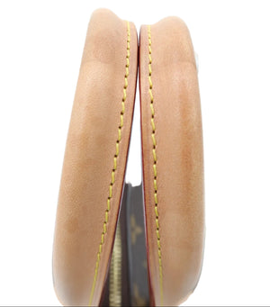 Close-up of a tan leather item showing the interior edge with yellow contrast stitching and a dark patterned lining.