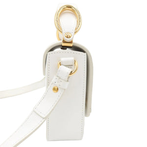 A close-up of a white leather handbag showing the side profile, featuring a white shoulder strap, a gold-tone metal ring detail, and a white zipper closure on a clean white background.