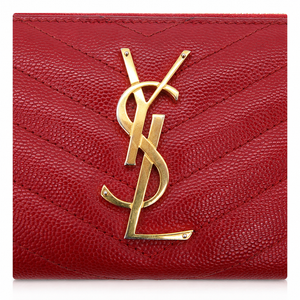 A close-up of a red pebbled leather wallet or card case with a large gold-tone interlocking YSL logo on the front, set against a plain white background.