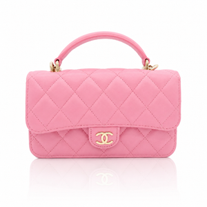 Chanel Mini Top Handle Rectangular Flap Bag in pink quilted lambskin, gold-tone interlocking CC logo, and a clean white background with a soft reflection below.