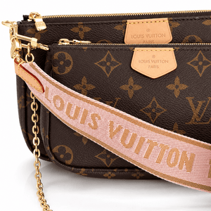 Close-up of Louis Vuitton Multi Pochette Accessoires in brown Monogram canvas showing the pink jacquard strap, leather logo tabs, zippers, and gold-tone hardware