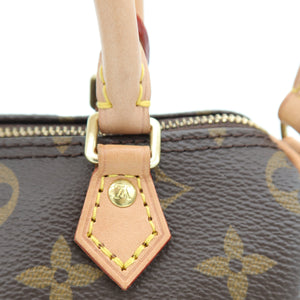Close-up of a Louis Vuitton monogram handbag in brown coated canvas with tan leather trim and gold-tone hardware, showing part of the zipper and a hanging leather tab with a visible LV logo.