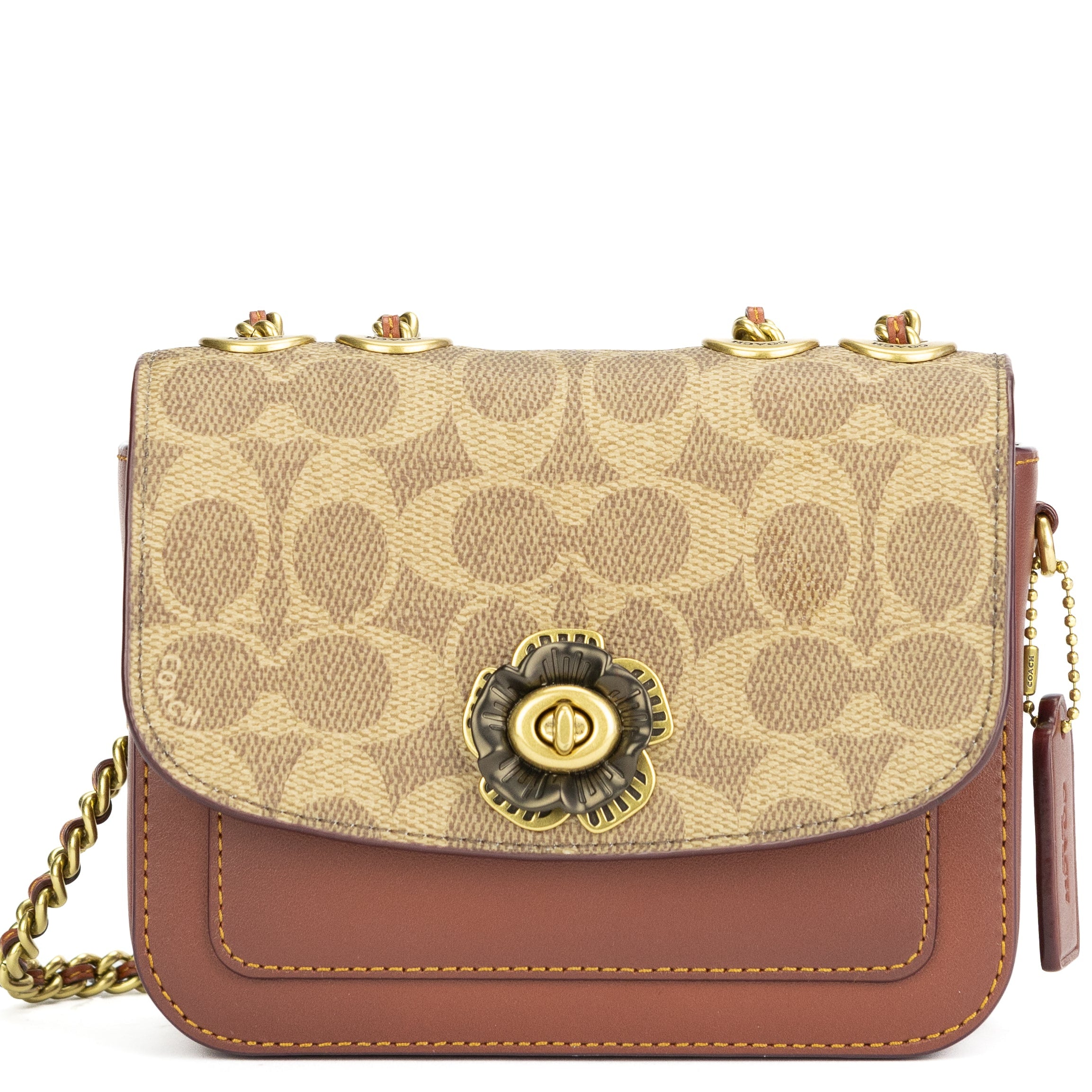 Beige and brown handbag with floral emblem on a white background