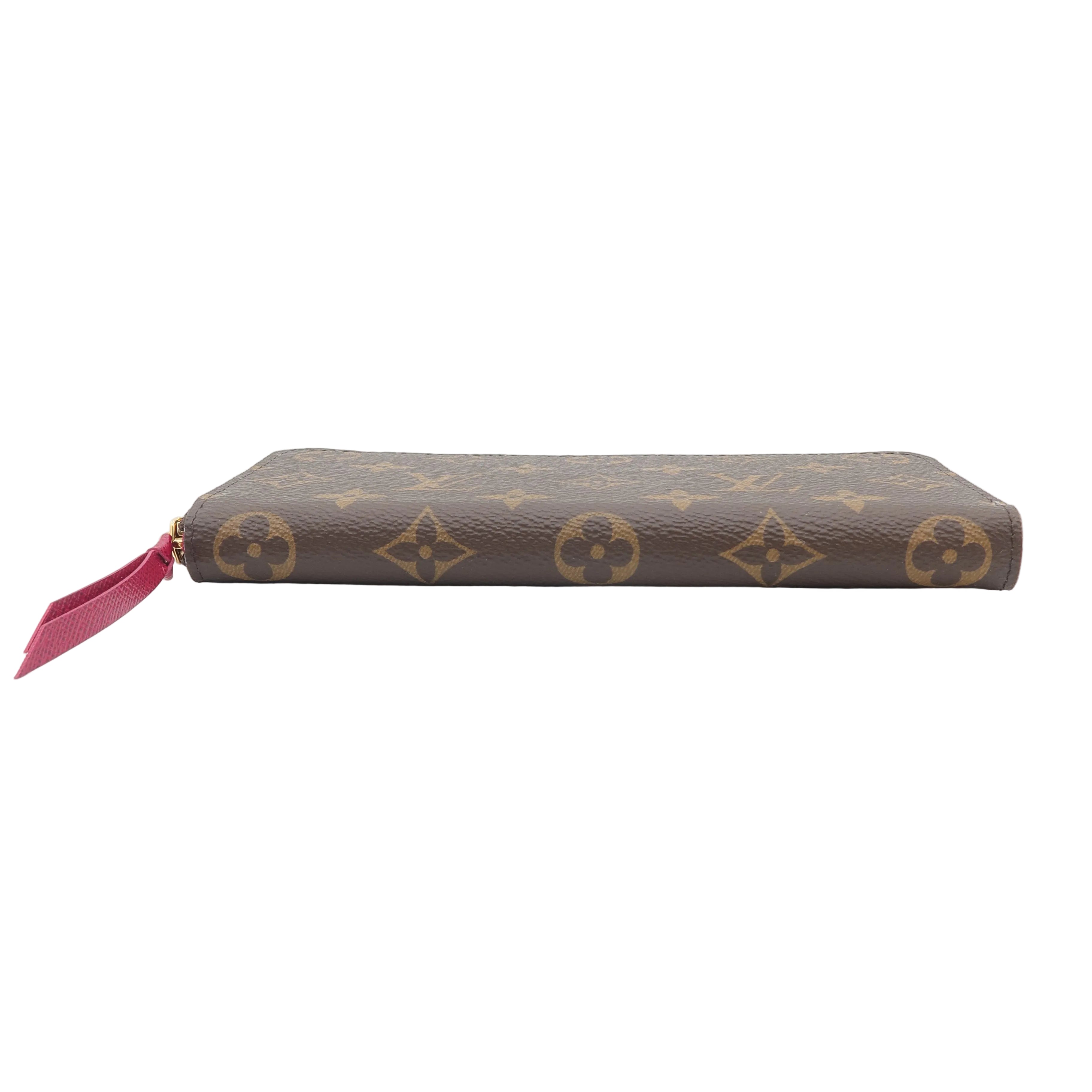 A Louis Vuitton monogram canvas zip-around wallet in brown with a small red zipper pull, shown against a plain white background.
