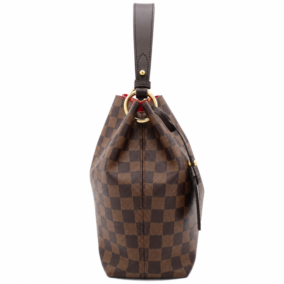 A Louis Vuitton bucket bag in the Damier Ebene checkered canvas, featuring a dark brown leather top handle, a gold-tone metal O-ring, and a red fabric lining visible at the top opening.
