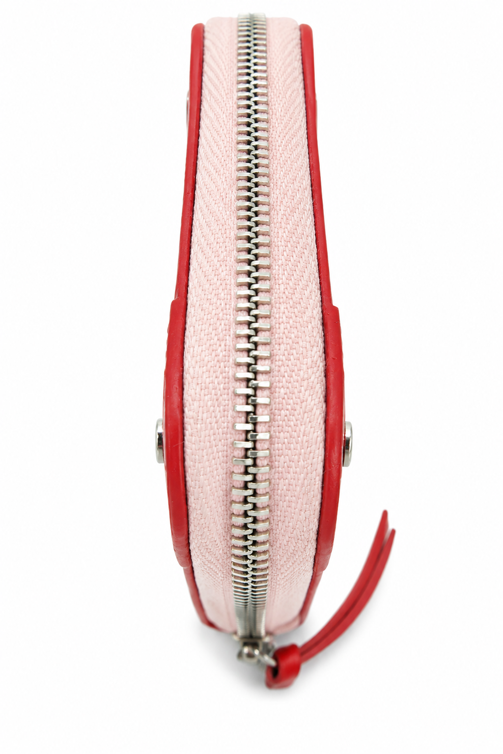 A close-up side view of a small zip-around pouch or coin purse with a light pink canvas-like center, red leather trim, and a silver zipper with a red pull tab, shown on a white background.