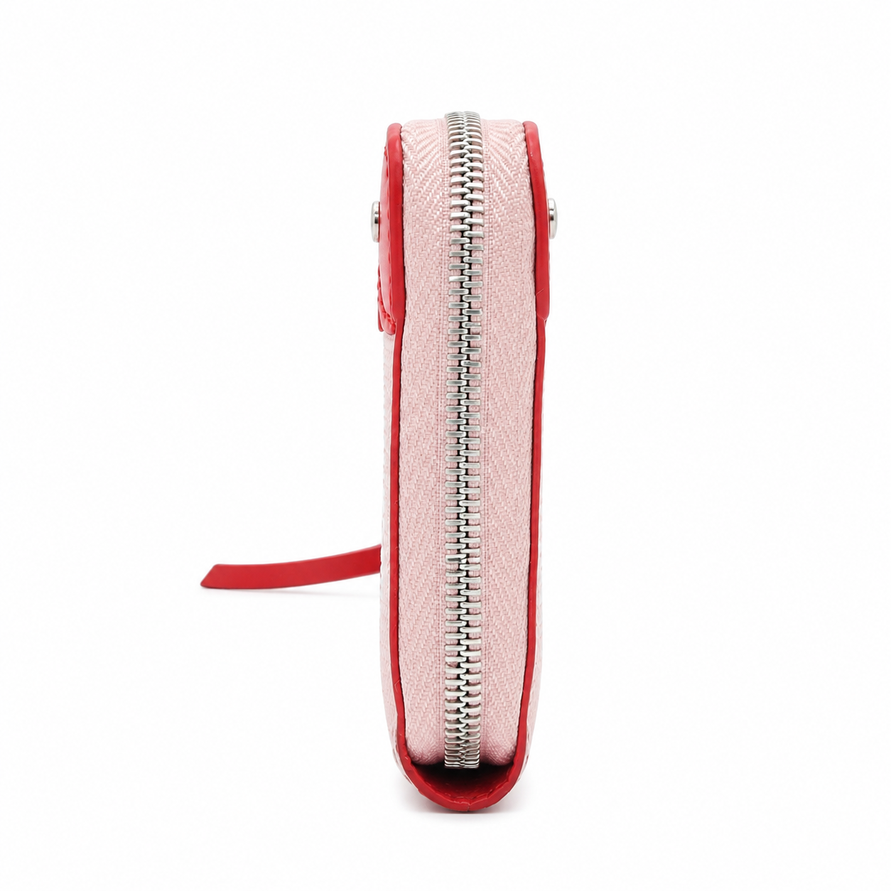 A slim zip-around pouch shown from the side on a plain white background. The pouch has a light pink textured exterior with a bright red inner lining and a silver metal zipper.