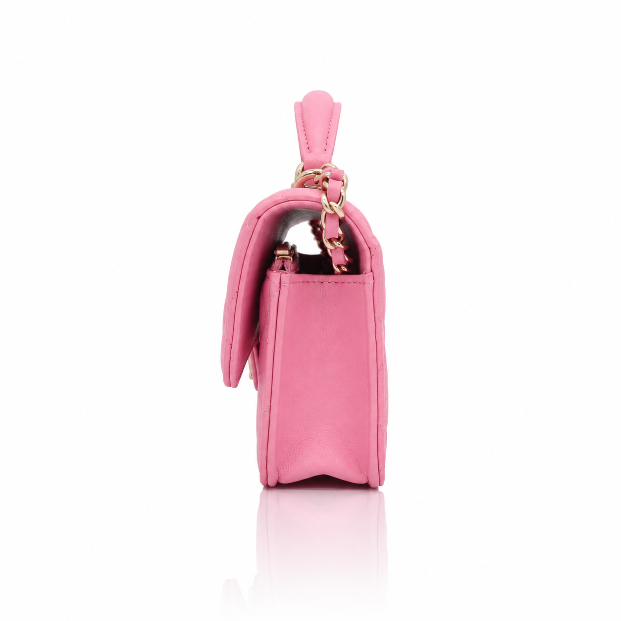 Chanel Mini Top Handle Rectangular Flap Bag in pink lambskin left side view featuring a top handle, gold-tone hardware, and a decorative pink bow charm, set against a clean white background with a soft reflection.