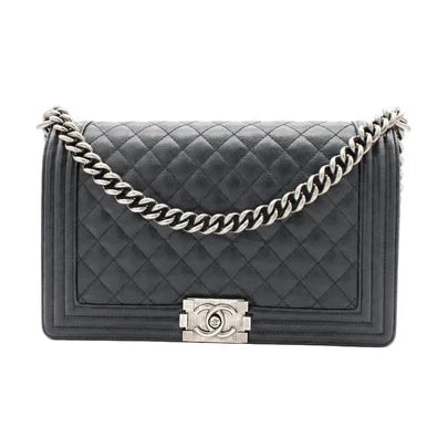 Black quilted handbag with a silver chain and clasp on a white background