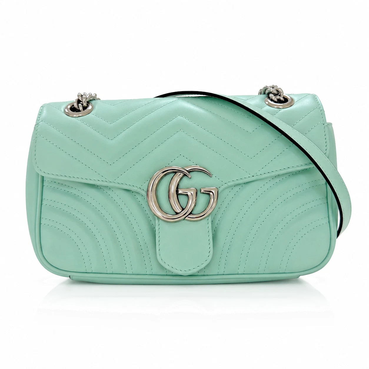 A mint green quilted leather shoulder bag with a silver-tone interlocking G logo on the front, a black strap, and silver-tone chain details, shown on a white background.