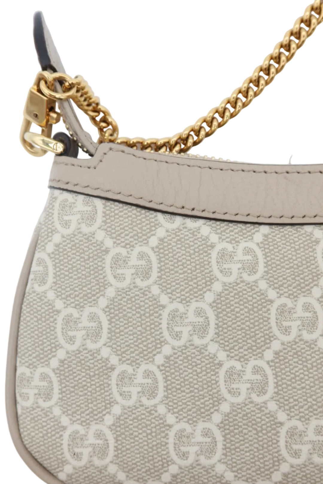 Close-up of a beige and off-white monogram handbag with a gold chain strap and gold hardware, featuring the interlocking GG pattern.