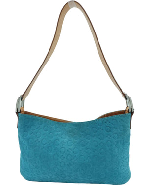 A turquoise blue shoulder bag with an embossed pattern, featuring a tan leather strap and silver-tone hardware, set against a light blue background.