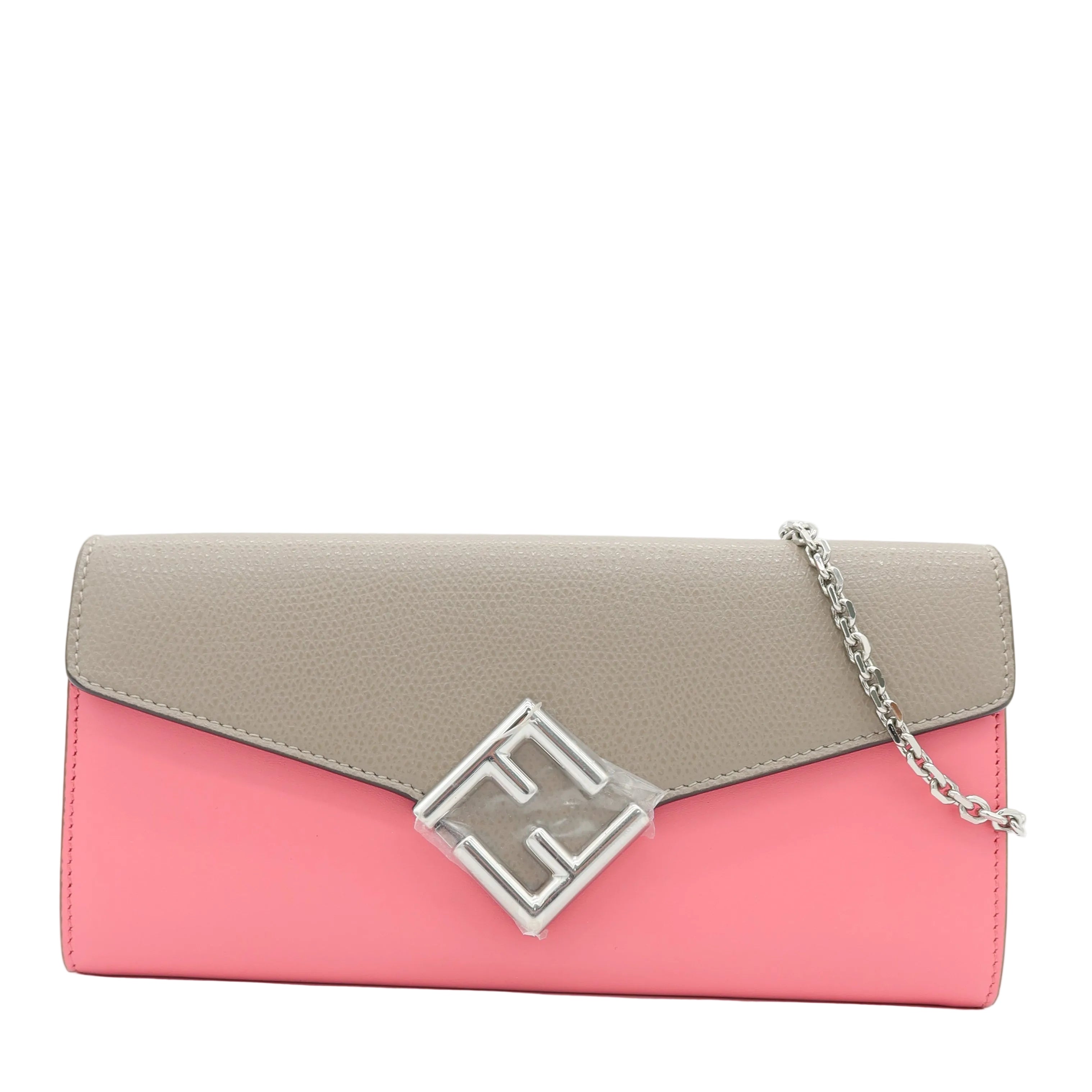 A color-blocked clutch bag with a light gray flap and a pink body, featuring a silver-tone geometric logo clasp and a silver chain strap, set against a plain white background.