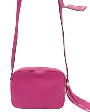 A bright pink textured leather crossbody bag with a matching pink strap and a tassel detail, shown against a plain white background.
