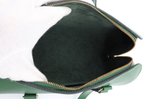 Close-up of the interior of a green leather handbag, showing a dark green suede-like lining and a gold-tone zipper.