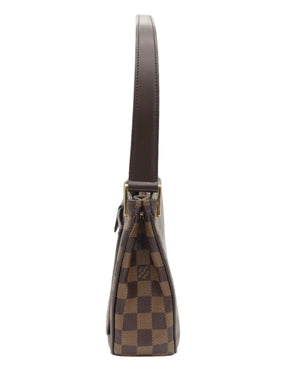 A Louis Vuitton shoulder bag in the Damier Ebene checkered canvas, shown from a side profile view against a white background.