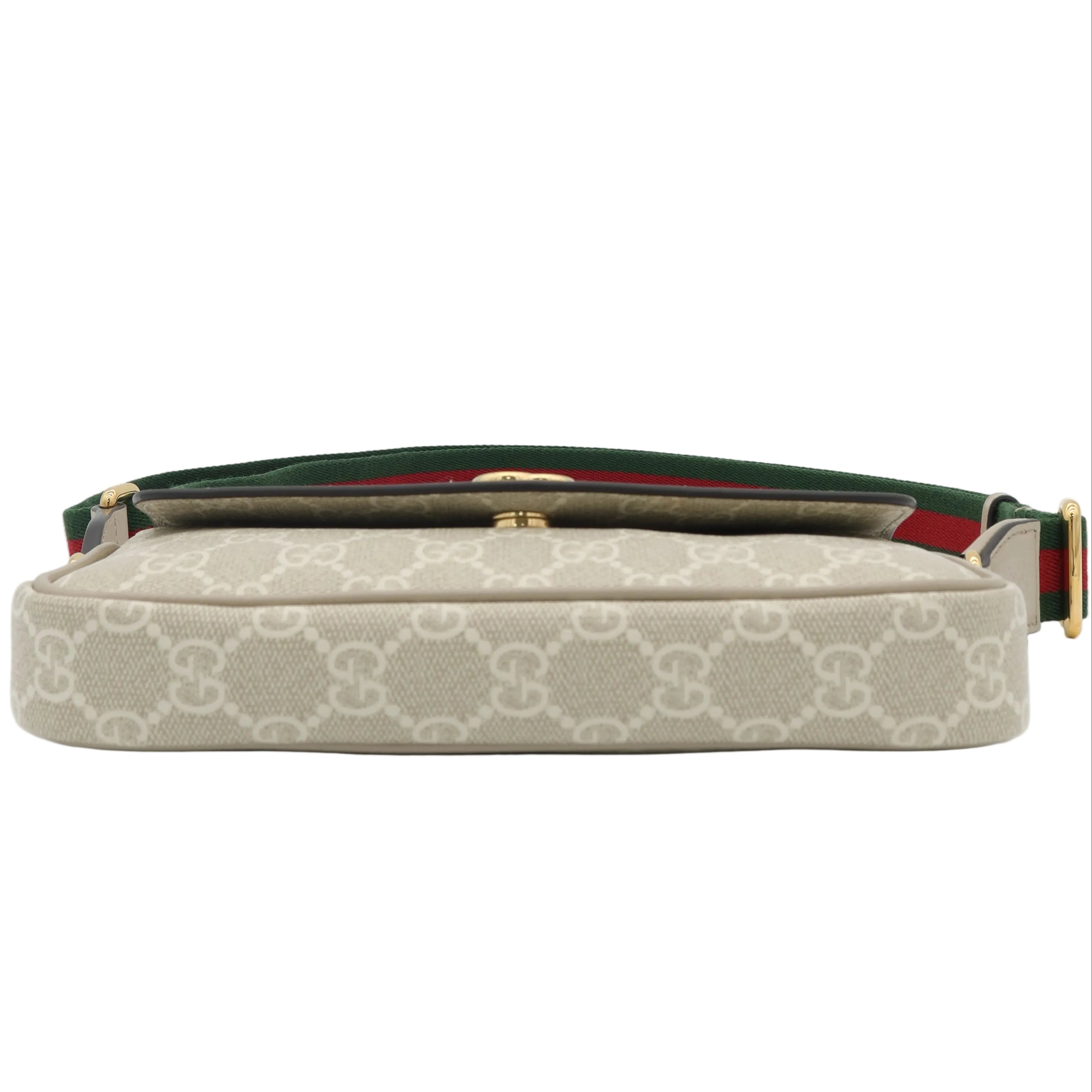 A Gucci shoulder bag in beige GG Supreme canvas with a green and red web stripe detail, shown against a plain light gray background.