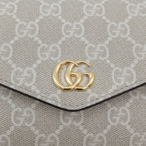 Close-up of a beige and off-white GG Supreme canvas pouch with a gold-tone interlocking G logo clasp on a clean white background.
