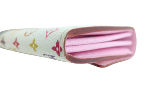 A close-up of a Louis Vuitton monogram wallet in white coated canvas with pink leather interior and brown edges, held by a white gloved hand against a white background.