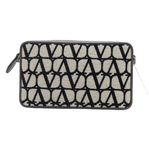 A rectangular clutch bag with a black and beige geometric pattern, featuring a top zipper closure and a small black leather loop on the left side, set against a plain white background.