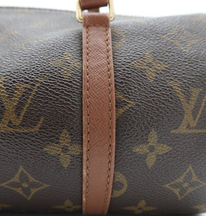 Close-up of a Louis Vuitton monogram canvas bag with a brown leather strap and gold-tone hardware, showing the classic LV monogram pattern.