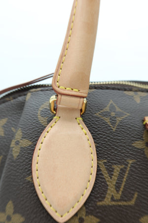 Close-up of a Louis Vuitton handbag in brown monogram canvas with a tan leather handle and gold-tone hardware.