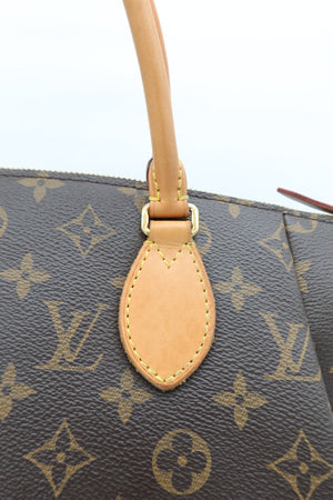 Close-up of a Louis Vuitton monogram handbag showing the dark brown coated canvas with tan monogram print, a tan leather handle attachment, and gold-tone hardware.