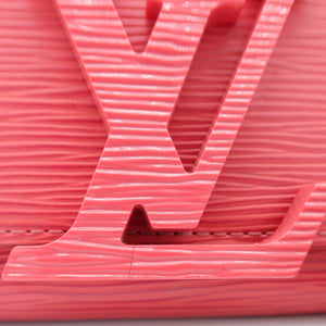 A close-up of a Louis Vuitton monogram bag featuring the interlocking LV logo in a textured, wavy coral-pink material, set against a clean white background.