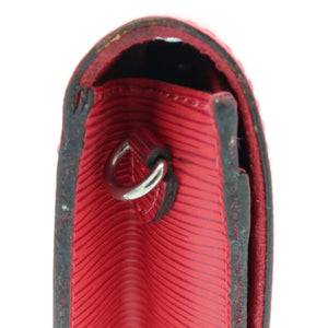 Close-up of a red leather accessory with a textured interior and a silver metal ring, shown against a plain white background.