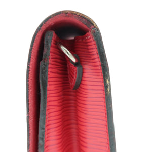 Close-up of a red textured leather zipper pull tab with a black leather loop and a silver metal zipper pull, set against a plain white background.