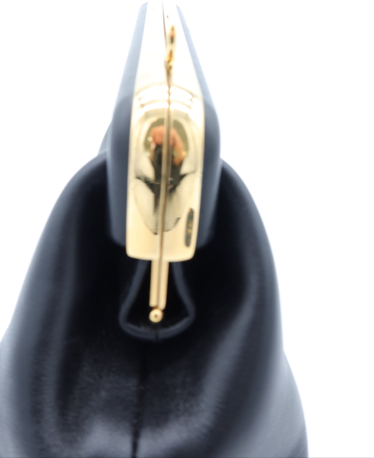 Close-up of a black leather handbag featuring a prominent gold-tone metal clasp on a white background.
