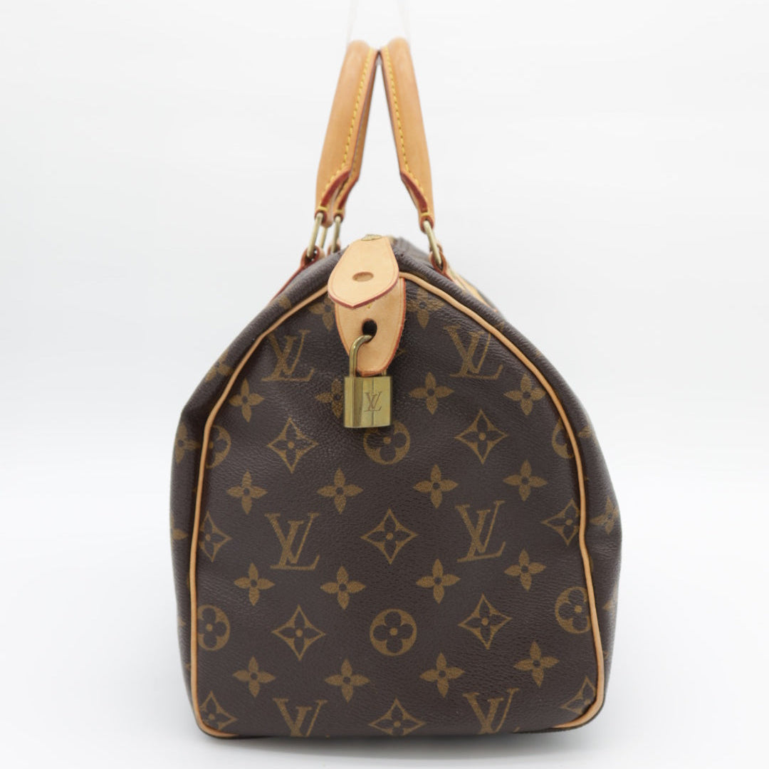A Louis Vuitton monogram canvas duffel bag in dark brown with tan leather handles and trim, shown against a plain white background.