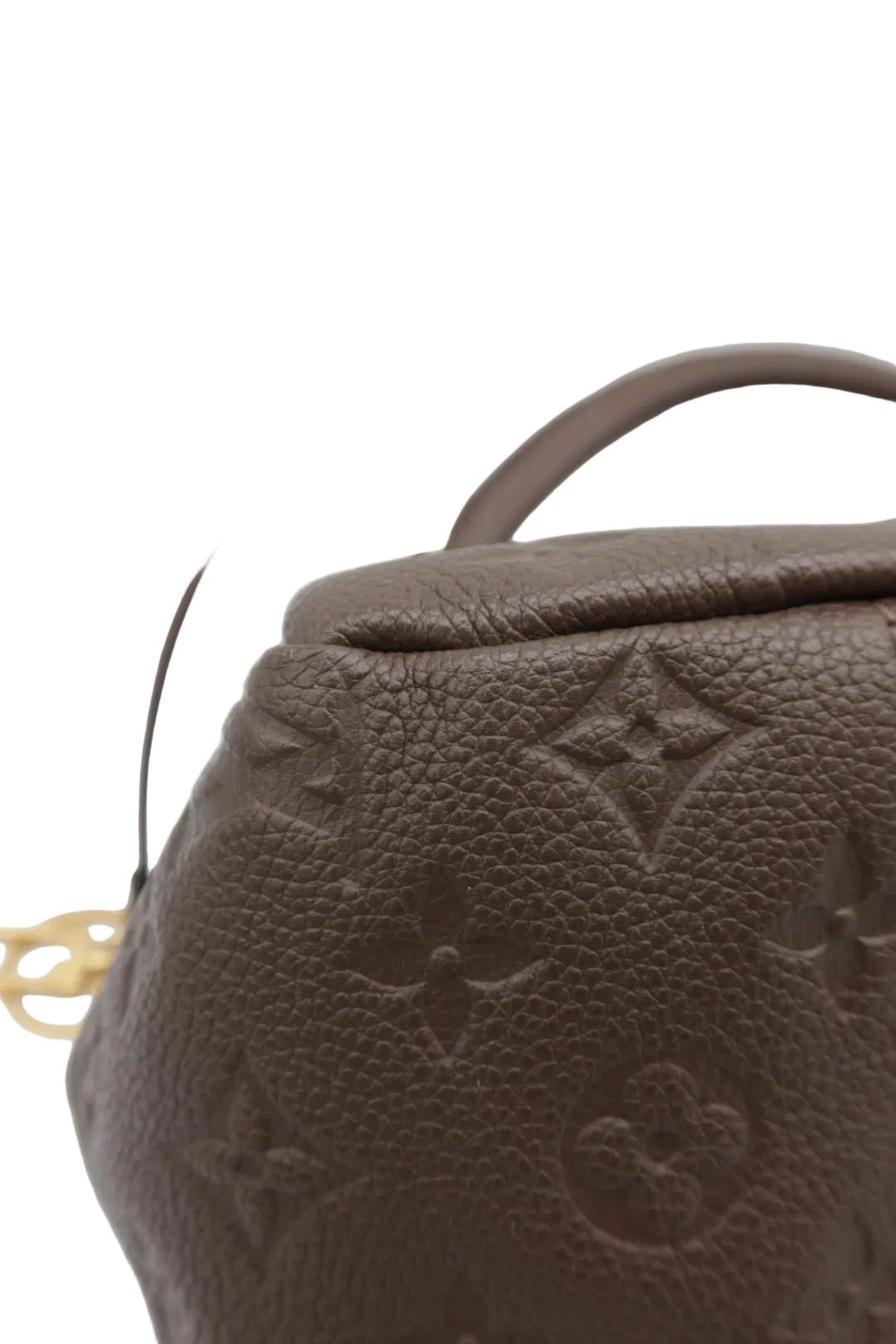 Close-up of a brown textured leather handbag with an embossed monogram pattern and a dark strap, photographed against a light gray background.
