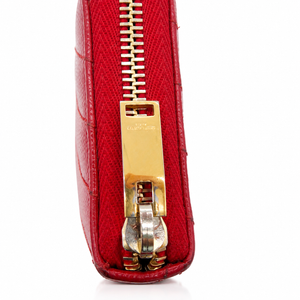 Saint Laurent YSL Red Chevron Grain de Poudre Zip Around Wallet Gold Logo Close-up of a red textured leather zippered clutch or wallet with a gold-tone metal zipper pull and silver-toned hardware, shown on a white background.