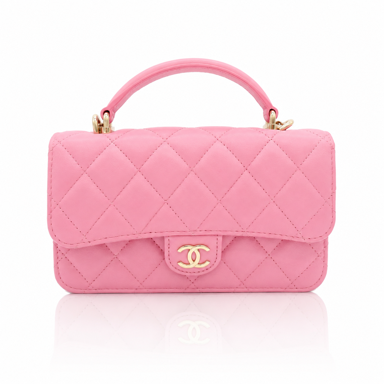 Chanel Mini Top Handle Rectangular Flap Bag in pink quilted lambskin, gold-tone interlocking CC logo, and a clean white background with a soft reflection below.