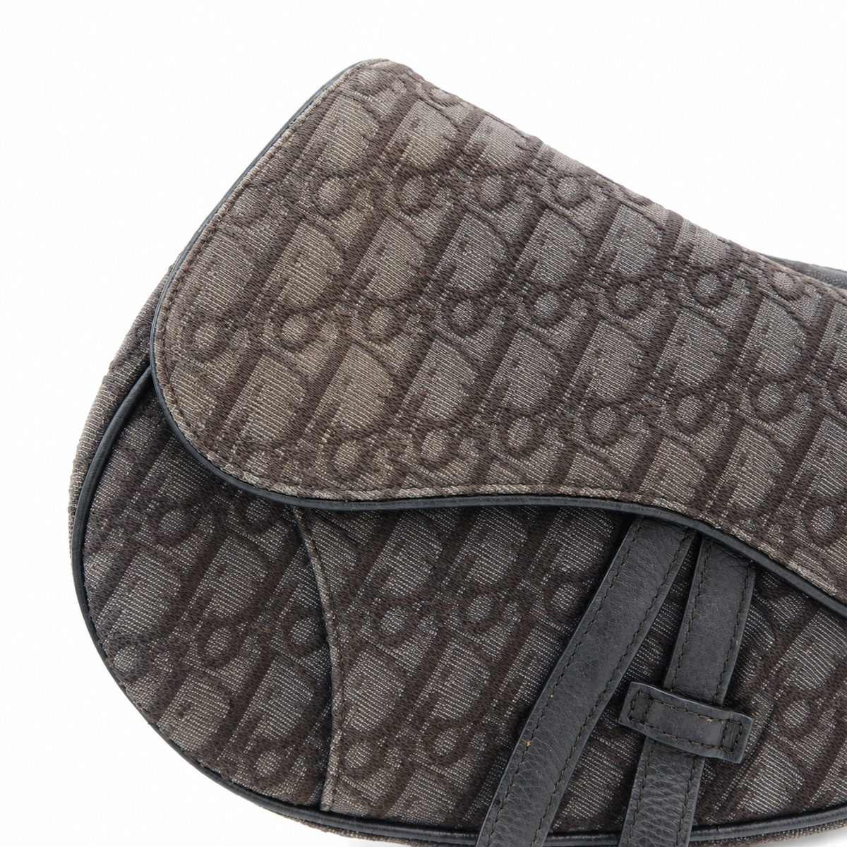 Close-up of a dark brown coated canvas bag featuring an allover monogram pattern and dark brown leather straps, set against a plain white background.