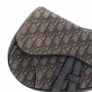Close-up of a dark brown coated canvas bag featuring an allover monogram pattern and dark brown leather straps, set against a plain white background.