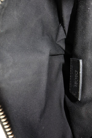 Close-up of a black fabric item with a small black leather tag embossed with the brand name Dior.
