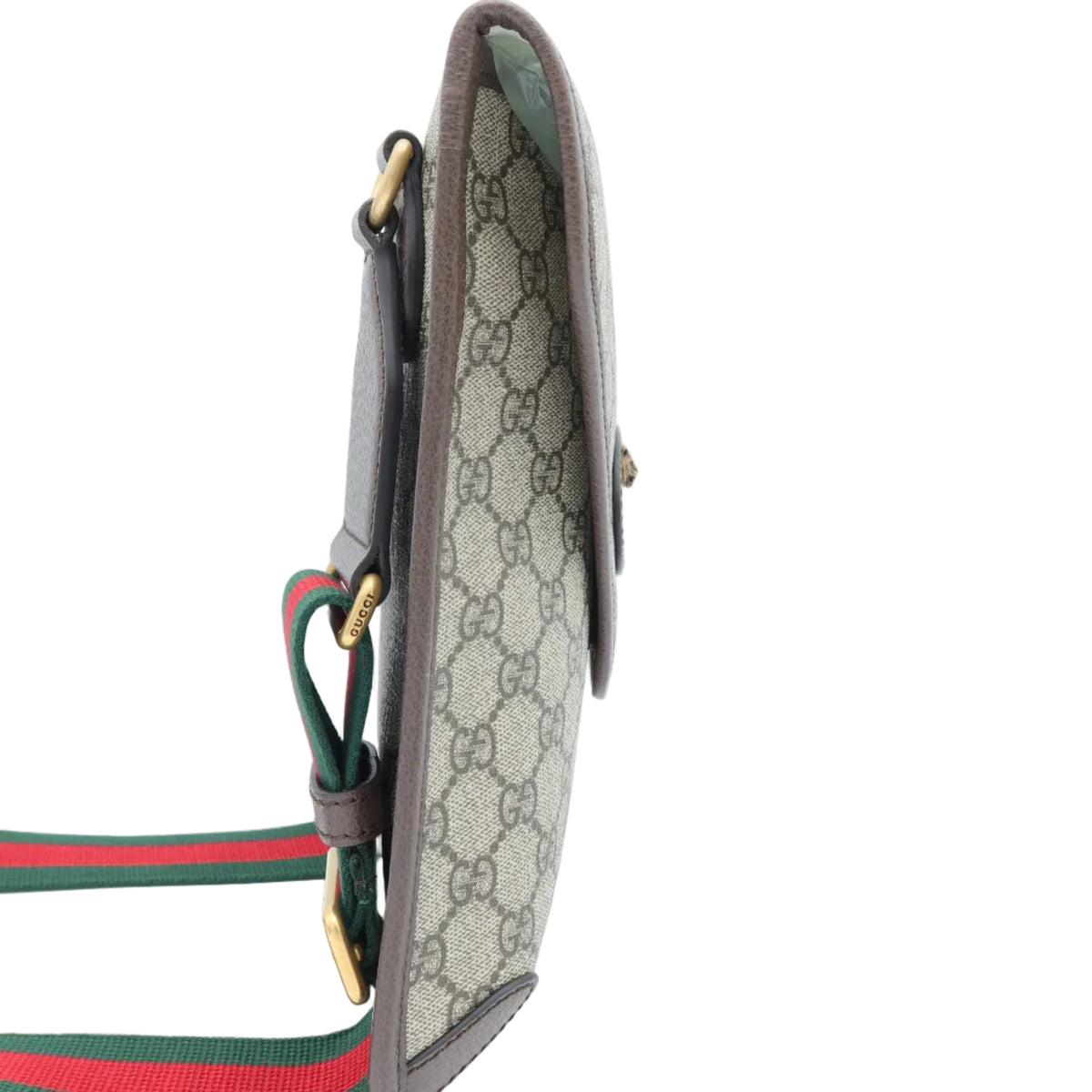 A Gucci monogram crossbody bag in beige GG Supreme canvas with brown leather trim and a signature green and red web stripe, shown on a white background.