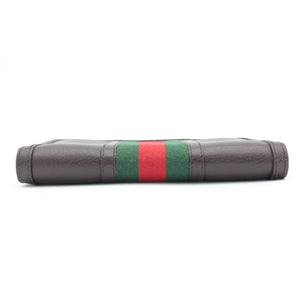 A dark brown leather clutch bag featuring the iconic green and red web stripe pattern on the front, set against a plain white background.