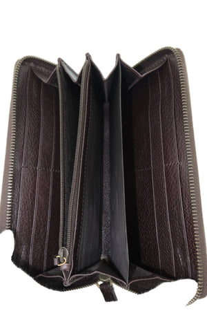 An open dark brown leather bi-fold wallet showing its interior card slots, zippered compartments, and lining, held open by a white gloved hand against a white background.